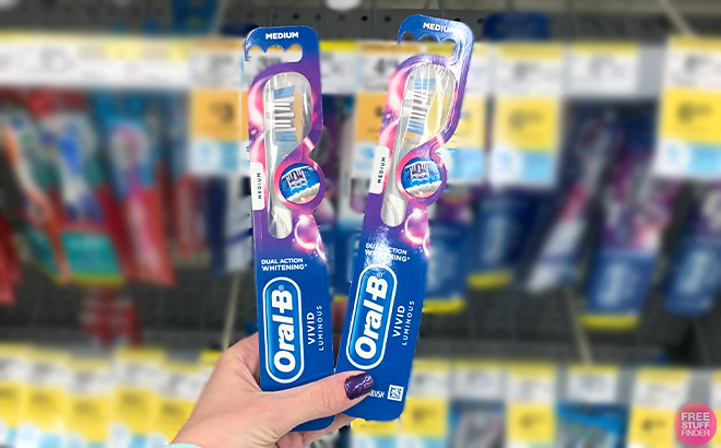 Hand holding two Oral B Toothbrush