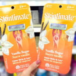 Hand holding two Schick Skintimate Disposable Razors 4 Count