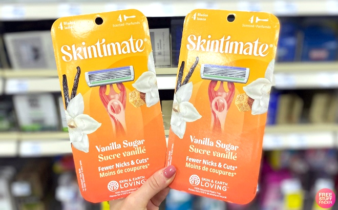 Hand holding two Schick Skintimate Disposable Razors 4 Count