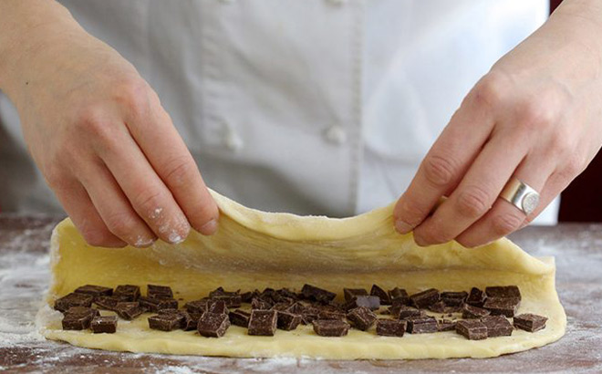 Hands Folding a raw Pastry Filled with Chocolate