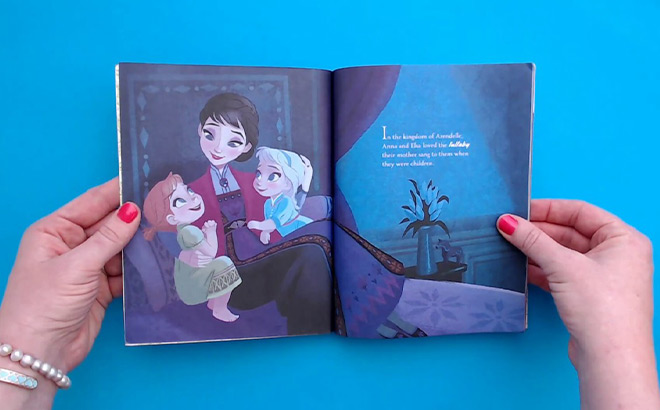 Hands Holding Open a Disney Frozen Book
