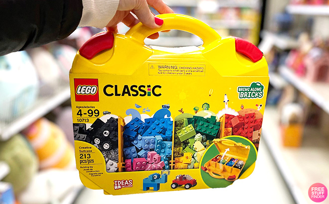 A Hand Holding the LEGO Classic 213-Piece Suitcase Set at a Store