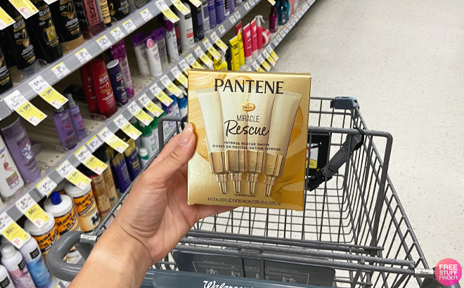 Person Holding Pantene Miracle Rescue Dry Hair Treatment Shots Above a Walgreens Cart