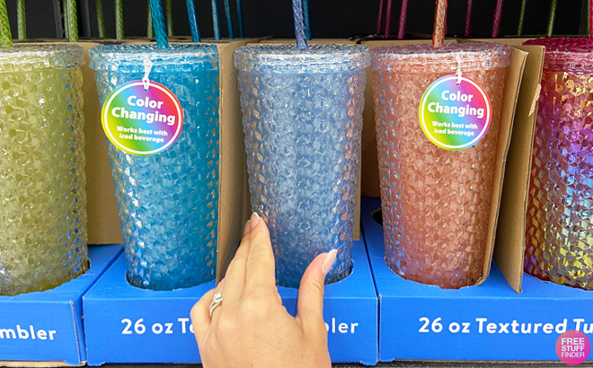 Three Mainstays 26 Ounce Color Changing Textured Tumblers on a Shelf at Walmart