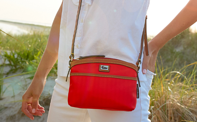 Woman Wearing Dooney & Bourke Wayfarer Domed Crossbody in Red Color