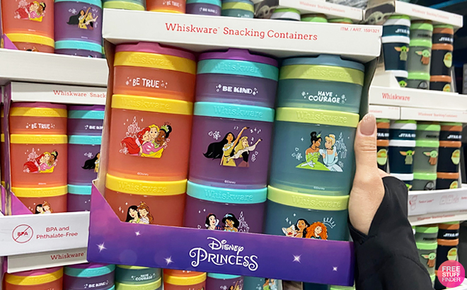 A Hand Holding Disney Princess Whiskware Snack Containers 3 Pack Inside Costco Store