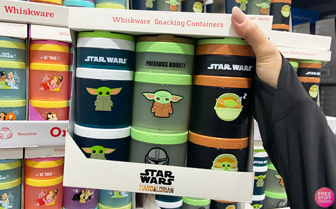 A Hand Holding Star Wars Whiskware 3 Pack Snack Containers Inside Costco Store