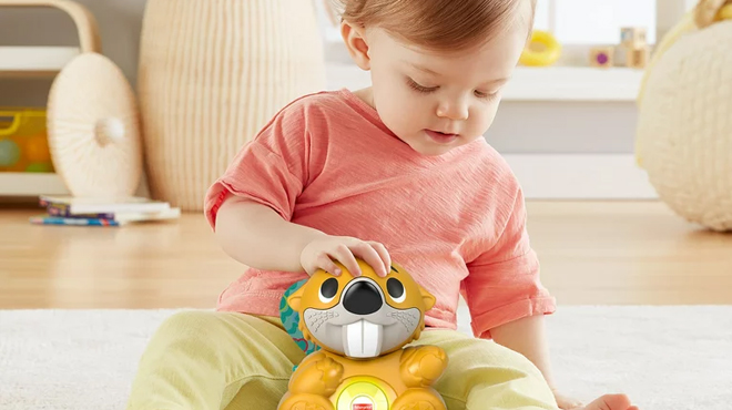 A boy playing Fisher Price Linkimals Beaver Toy