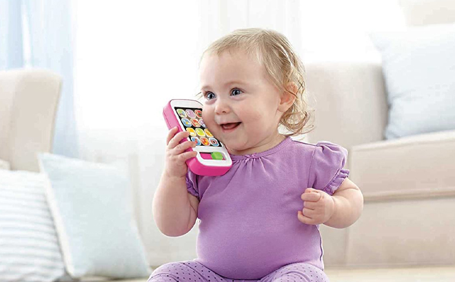 Baby Holding Fisher Price Smart Phone Toy 1