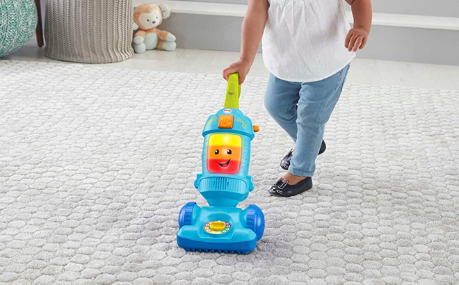 Child Holding Fisher Price Learning Vacuum Toy 1