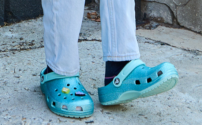 Girl Wearing Crocs Classic Glitter Clogs in Pure Water