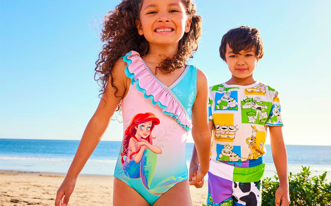 Girl Wearing Little Mermaid Swimsuit and Boy Wearing Disney Swim Set on a Beach
