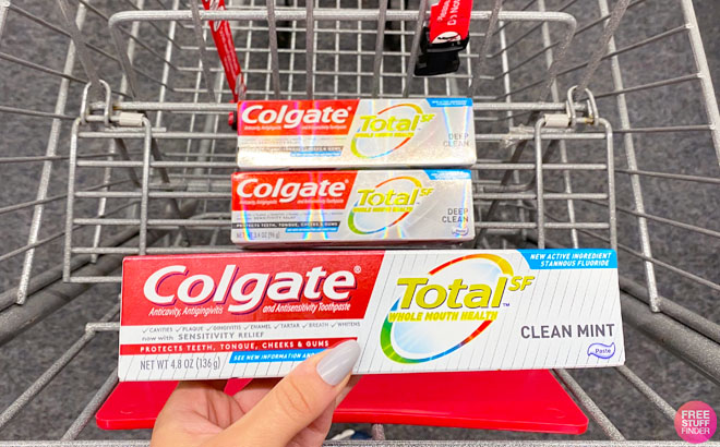 Hand Holding Colgate Total Clean Mint Toothpaste over CVS Cart