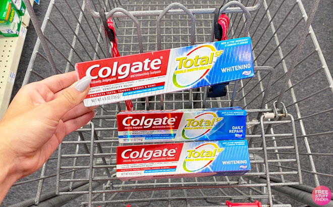 Hand Holding Colgate Total Whitening Toothpaste 4 8 Ounces above CVS Cart