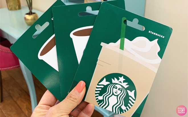 Hand Holding Three Starbucks Gift Cards