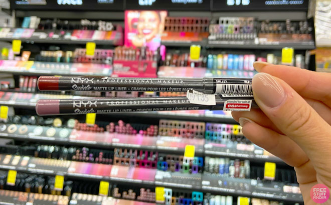 Hand Holding Two NYX Professional Suede Lip Liners Inside a Store