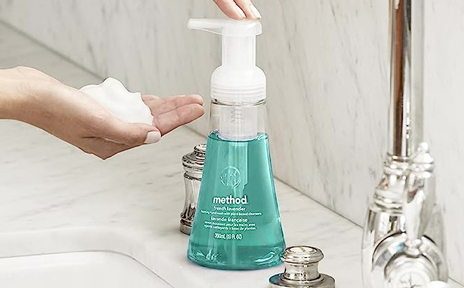 Lady Pumping a Bottle of Method Foaming Hand Soap onto Her Hand