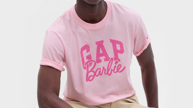 Young man wearing GAP x Barbie Adult Arch Logo Pink Tee