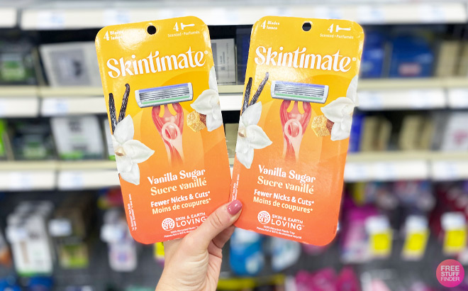 a Hand Holding Two 4 Count Packs of Skintimate Razors