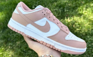 A Hand Holding Nike Dunk Low in Rose Whisper Color