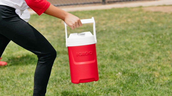 A Hand Holding an Igloo Half Gallon Sport Beverage Jug with Hooks in Red