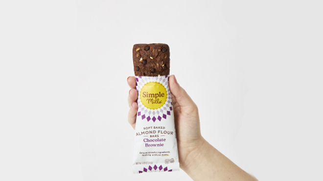 A hand holding Simple Mills Soft Baked Brownie Bars