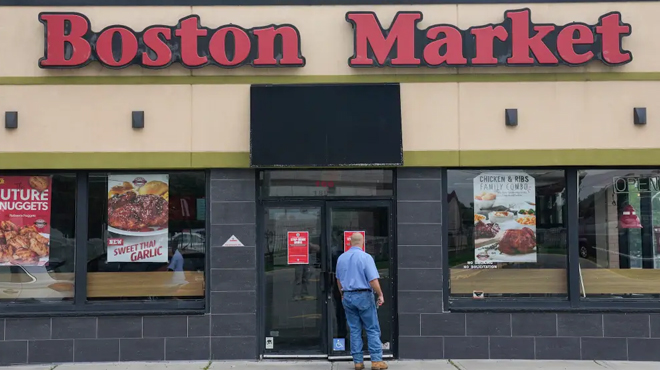A man reads a stop work order posted on the door of a Boston Market restaurant in Hackensack New Jersey