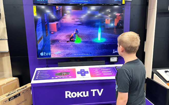 Boy in front of a Roku Select 65 Inch Smart TV inside a store