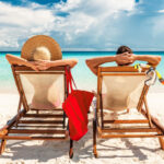Couple on a Beach Relaxing in Lounging Chairs