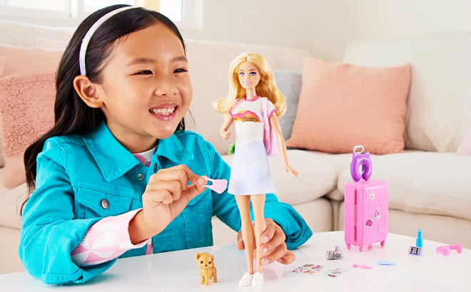 Girl Playing with Barbie Toy Travel Set with Puppy