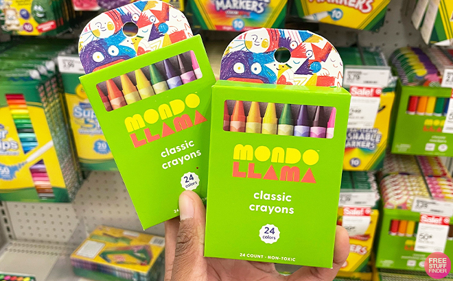 Hand Holding 2 Boxes of Mondo Llama 24ct Crayons Classic Colors at Target