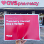 Hand Holding CVS Photo Prints in an Envelope in front of a CVS Store