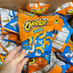Hand Holding Cheetos Cheese Puffs