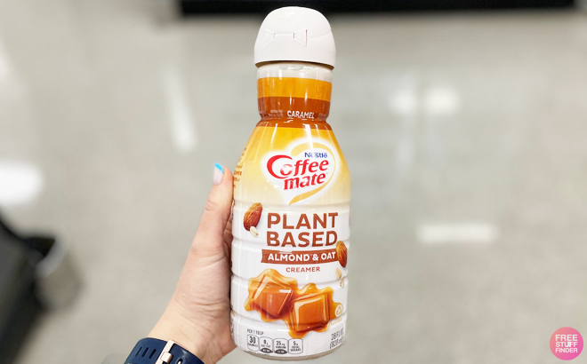 Hand Holding Coffee Mate Almond Oat Plant Based Coffee Creamer