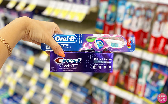 Hand Holding Crest 3D White Toothpaste and Oral B Toothbrush
