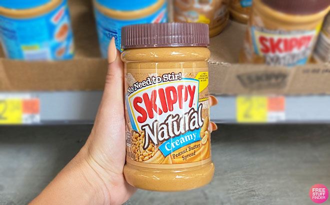Hand Holding Skippy Peanut Butter Spread Natural Creamy