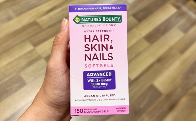 Hand Holding a Box of Natures Bounty Hair Skin Nails 150 Count Softgels