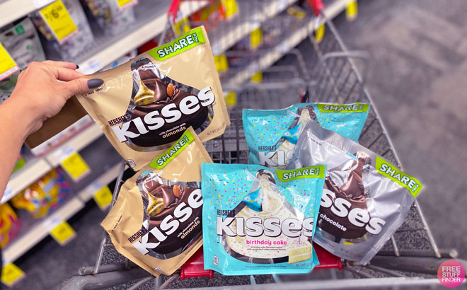 Hand Holding one Hersheys Kisses Candy Bag over a CVS Cart Containing Five Hersheys Kisses Candy Bags