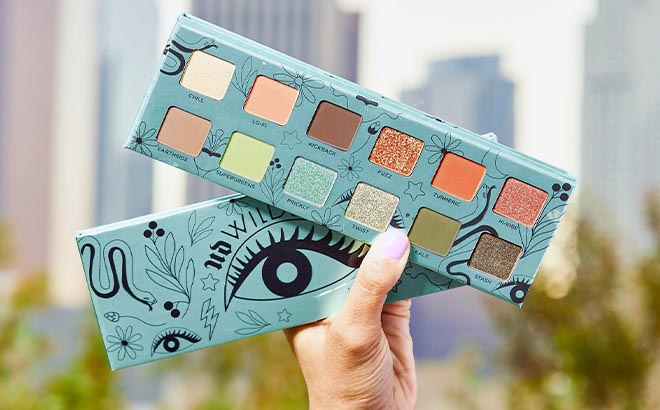 Hand holding Urban Decay Wild Greens Eyeshadow Palette