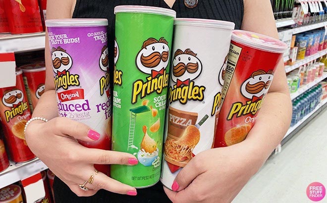 Hand holding cans of pringles