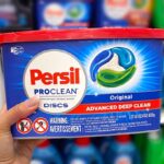 Hand holding one Persil Discs Laundry Detergent Pacs 40 Count