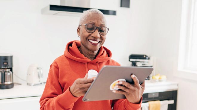 Lady in her 50s smilling and shopping through a Tab