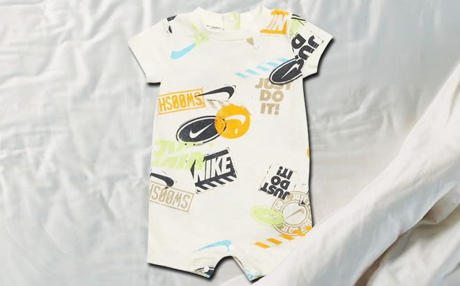 Nike Wild Air Allover Print Baby Romper on a Bed