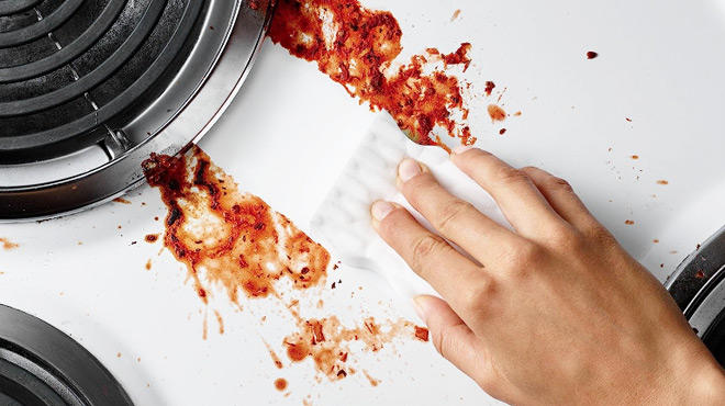 Person Cleaning Grease with Mr Clean Extra Durable Magic Eraser Person Cleaning Grease with Mr Clean Extra Durable Magic Eraser