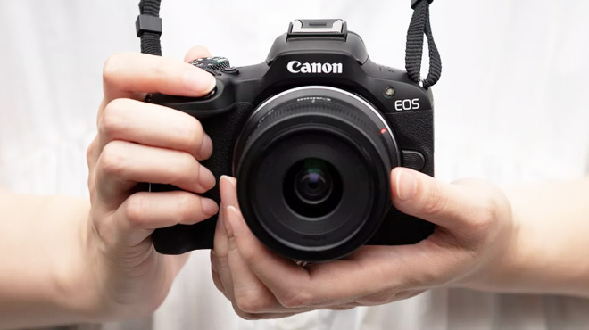 Young Woman Holding a Canon EOS R50 Mirrorless Camera