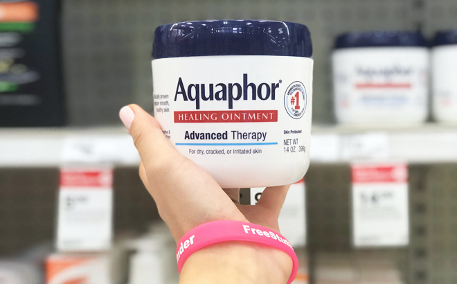 A Hand Holding Aquaphor Healing Ointment Jar