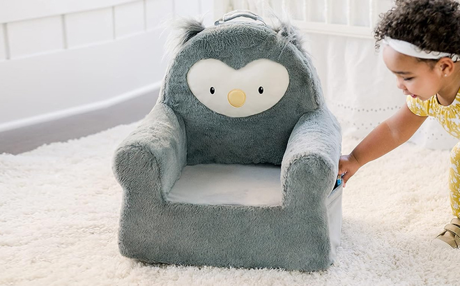 A Toddler Holding the Plush Character Chair in Owl Design