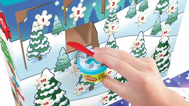 A hand opening a date and taking out a Play doh from the Play Doh Advent Calendar