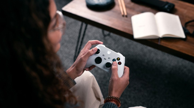 A lady using Xbox Core Wireless Controller in robot white color A lady using Xbox Core Wireless Controller in robot white color