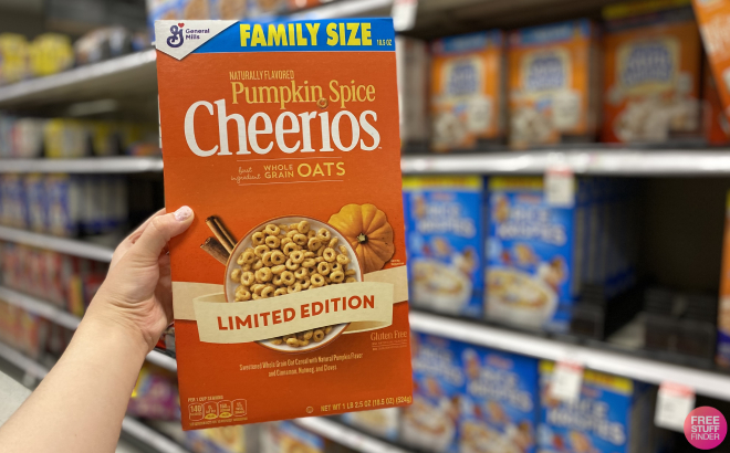 Hand Holding General Mills Pumpkin Spice Cheerios Family Size Cereal